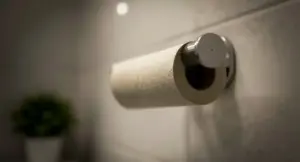 Un rotolo di carta igienica finito su un supporto da parete in bagno