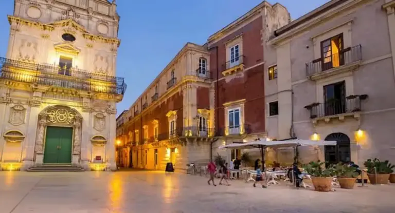Piazza storica in Sicilia con edifici barocchi illuminati al tramonto