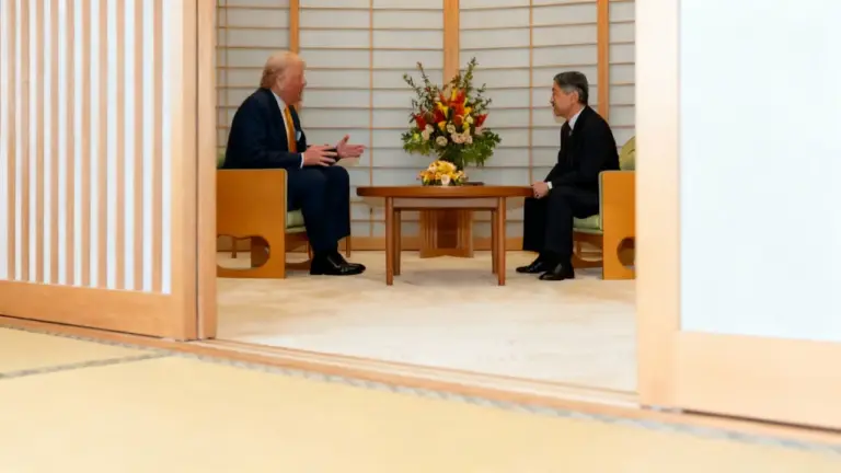 Due persone sedute in una sala giapponese tradizionale durante un incontro ufficiale