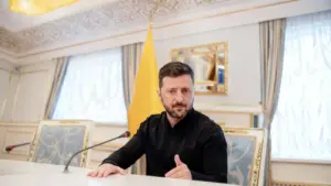 Una persona seduta a un tavolo durante una conferenza stampa in un ambiente formale