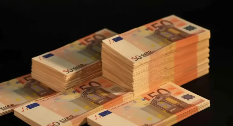 Mazzi di banconote da 50 euro disposti su una superficie scura