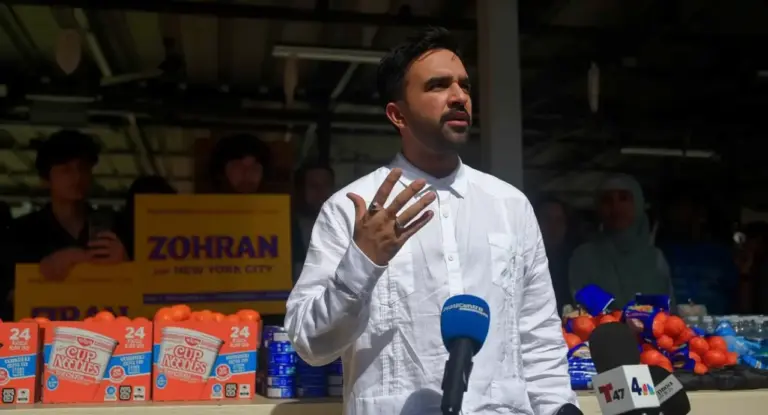 Una persona parla davanti a microfoni durante un evento pubblico