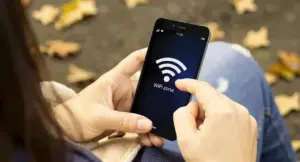 Persona usa uno smartphone per connettersi a una rete WiFi all'aperto.
