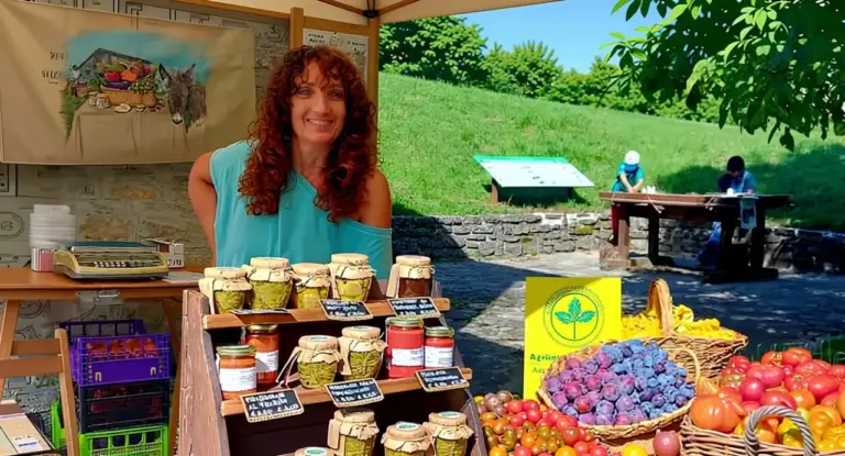 Donna a un banco agricolo con conserve artigianali e cesti di frutta antica in un mercato all’aperto
