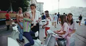 Gruppo di giovani con scooter 50cc parcheggiati vicino al mare