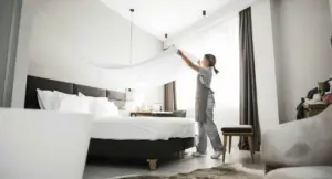 Una persona sistema le lenzuola in una stanza luminosa di un B&B