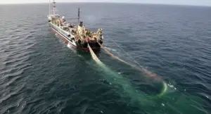 Peschereccio in mare aperto con reti da pesca in acqua