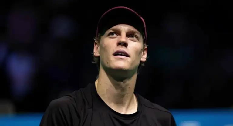 Un giovane atleta con cappellino osserva verso l’alto in un ambiente indoor
